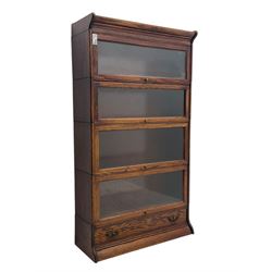 Early 20th century oak stacking library bookcase, four sections enclosed by hinged and sliding glazed doors, fitted with single drawer 