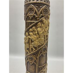 Vase of cylindrical form decorated in relief with spiralled bands of figures with drinks and animals in raucous scenes with alternating bands of classic church style windows, raised upon circular spreading base with faces, H40cm 
