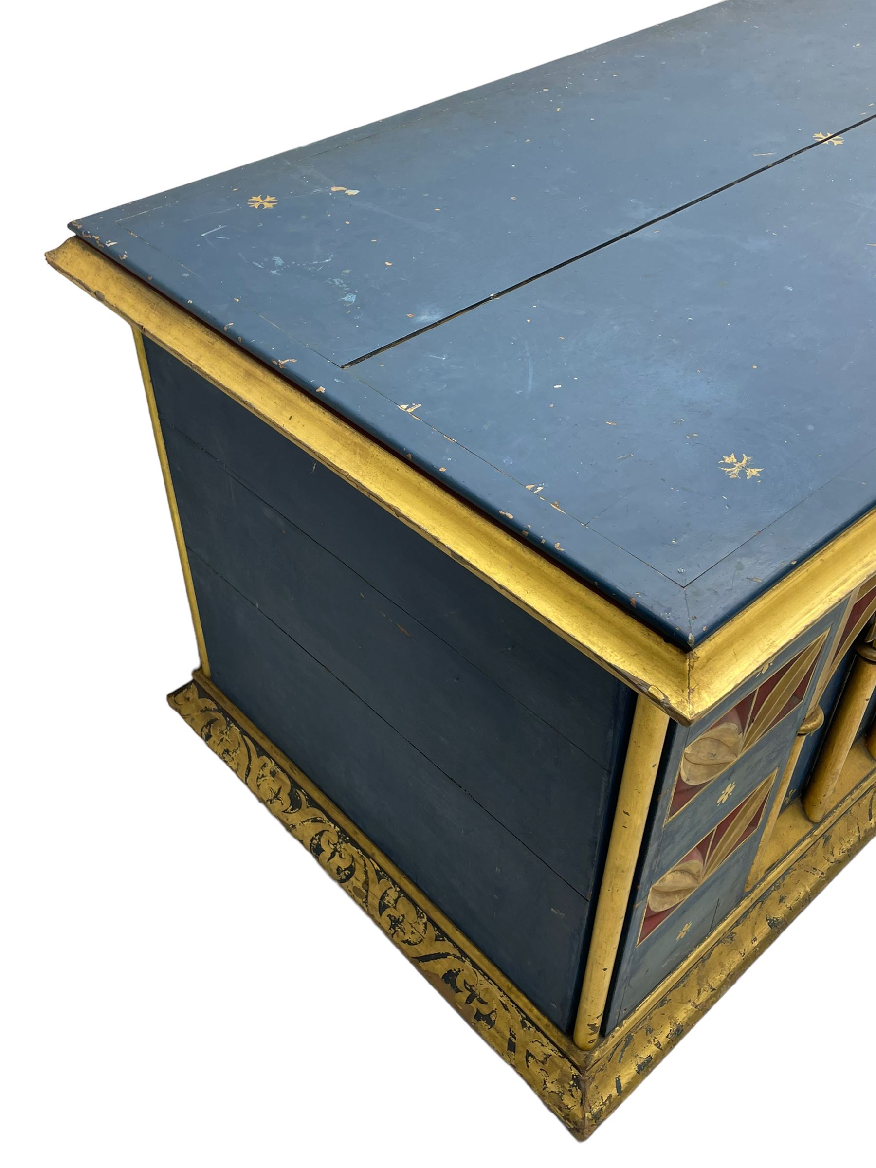 In the manner of William Burges - mid-to-late 19th century English Gothic Revival pine altar or console table, in blue and red paint with water gilding, the moulded rectangular top over six pointed arches with turned column supports, the front carved with a single row of lozenges and incised stylised motifs