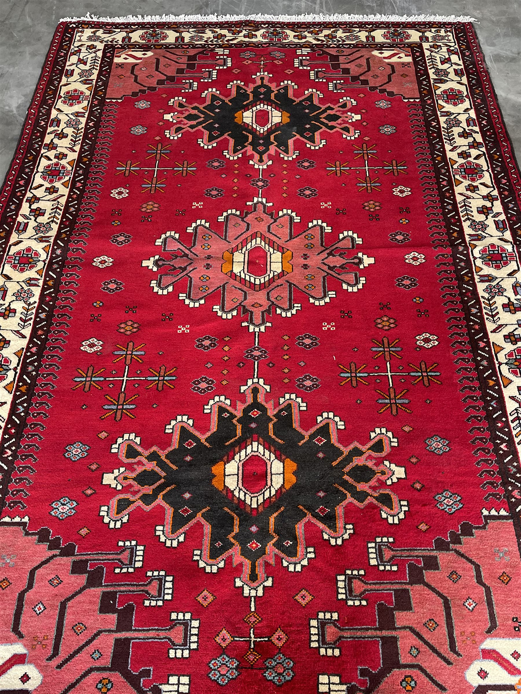 Persian Hamandan rug, the red ground field decorated with triple medallions and stylised motifs