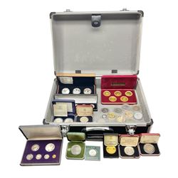 The Royal Mint United Kingdom 1977 silver proof two coin set, Queen Elizabeth II 2002 silver proof three coin set, comprising Bailiwick of Jersey, Bailiwick of Guernsey, and Alderney five pound coins, 'First Coinage of the British Virgin Islands' proof set, 1997 1/10 ounce fine silver Britannia, two King George V 1935 'Rocking Horse' crowns, various Isle of Man commemorative crowns, etc., house in a hard shell carry case