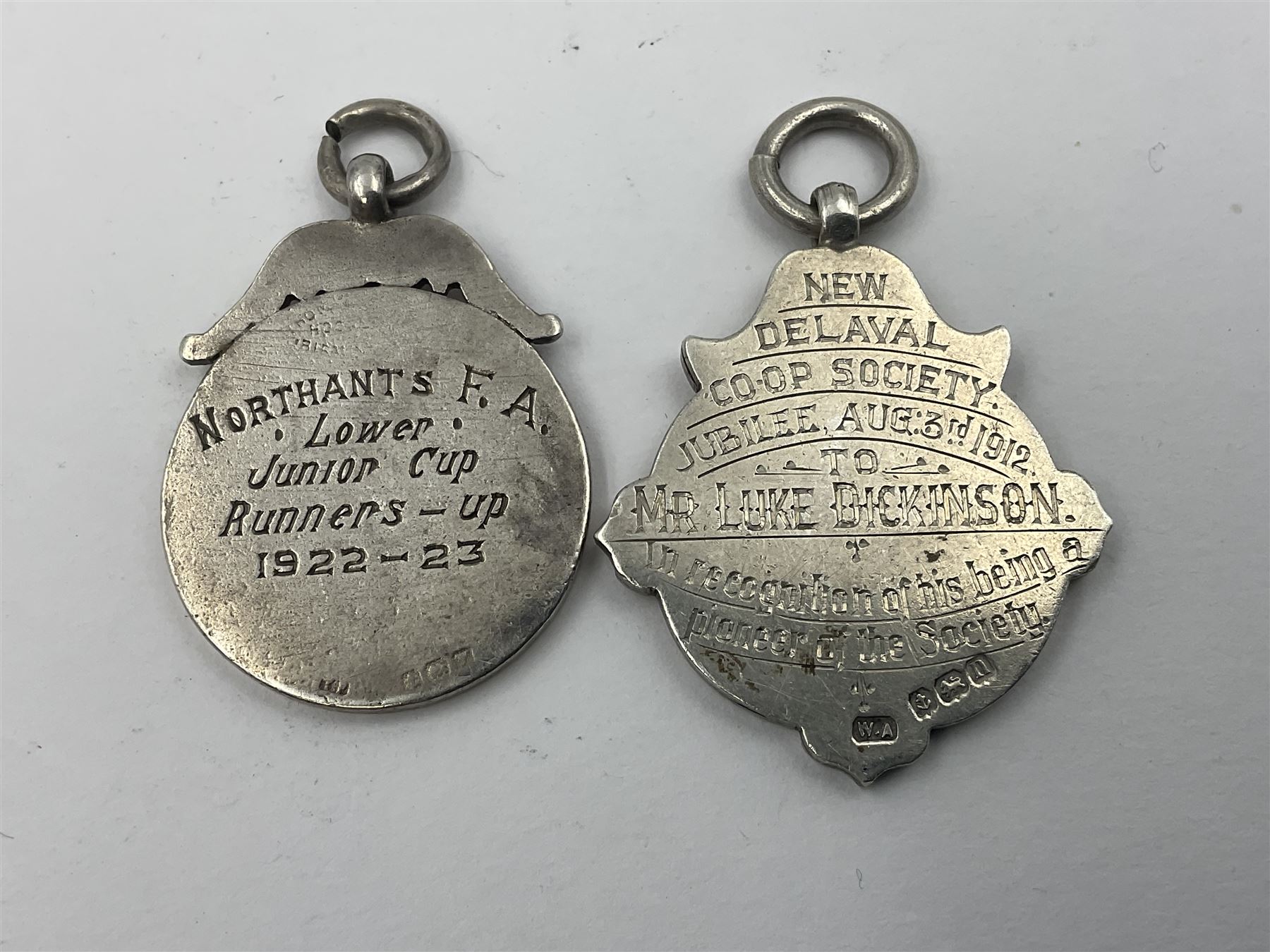 Seven early 20th century silver gold faced cartouche fobs, to include a circular example, with rose gold border and cartouche within an embossed yellow gold border, engraved verso, and a double sided example, all hallmarked with various dates and makers
