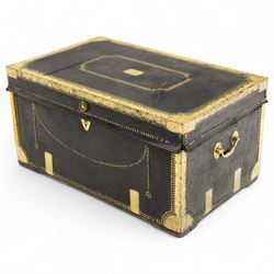 An early 19th-century Georgian brass-bound travelling trunk, leather-covered exterior with brass stud work decoration, front with central brass lock plate, hinged lid with camphor wood interior, external sides fitted with large brass carrying handles 