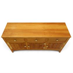 Traditional cherrywood sideboard, rectangular top above three fielded panelled drawers, three cupboard doors with triple panelled doors, brass knobs and hinges, tapered supports
