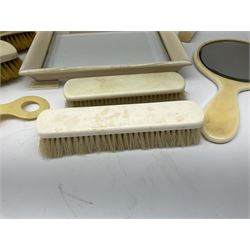 Early 20th century ivory dressing table set, comprising small footed tray with glass centre, handheld mirror, two hair brushes, two clothes brushes, cylindrical toothpick/pin case and shoe horn. 