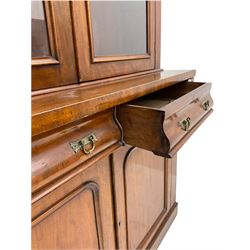 Victorian mahogany bookcase on cupboard, projecting cornice over two glazed doors and carved corbels, fitted with two drawers and double cupboard, plinth base