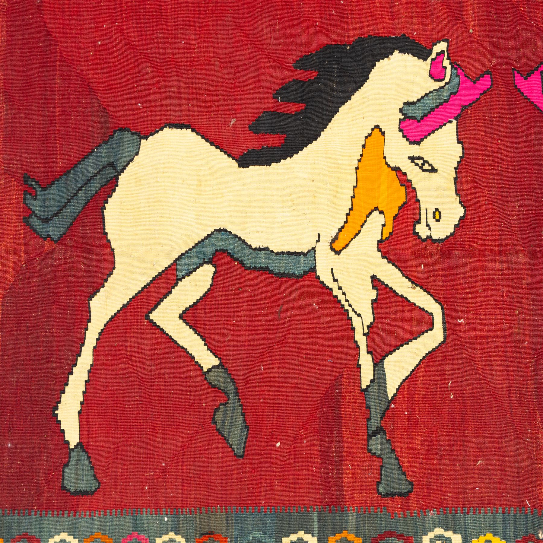 Southwest Persian Qashqai kilim, flatwoven wool with central pictorial design of mirrored horses on a red ground, framed by multicoloured motifs and stepped ivory border, vibrant palette throughout