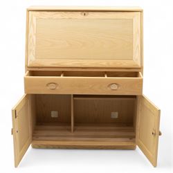 Ercol - light elm bureau, fitted with fall-front writing surface revealing adjustable shelving, above a single long drawer and twin cupboard doors, on plinth base