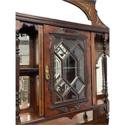 Victorian inlaid rosewood mirror back display cabinet, the shaped arched pediment  over central cabinet enclosed by astragal glazed doors, turned and reed carved upright supports, fitted with bevelled glass mirror plates, the break-front lower section with moulded top over bevel glazed mirror door, inlaid profusely with scrolling foliage, on turned feet