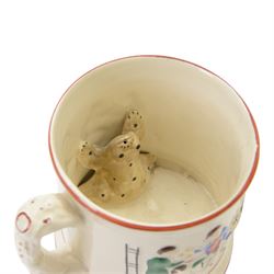 19th century frog and newt cup, decorated with a house in a landscape and cows, featuring a frog and newt inside the cup, together with three other frog cups 