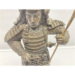 Bronze figure of a samurai standing wearing armour and holding a naginata, upon a rocky base, H48cm