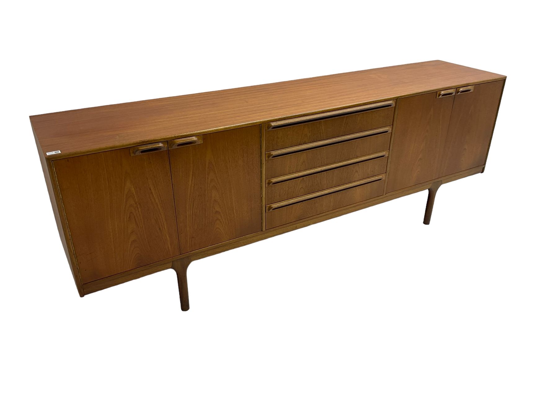 Tom Robertson for AH McIntosh & Co of Kirkaldy - mid-20th century teak sideboard, fitted with four central drawers, flanked by cupboard enclosing shelves and sliding tray, raised on cylindrical supports