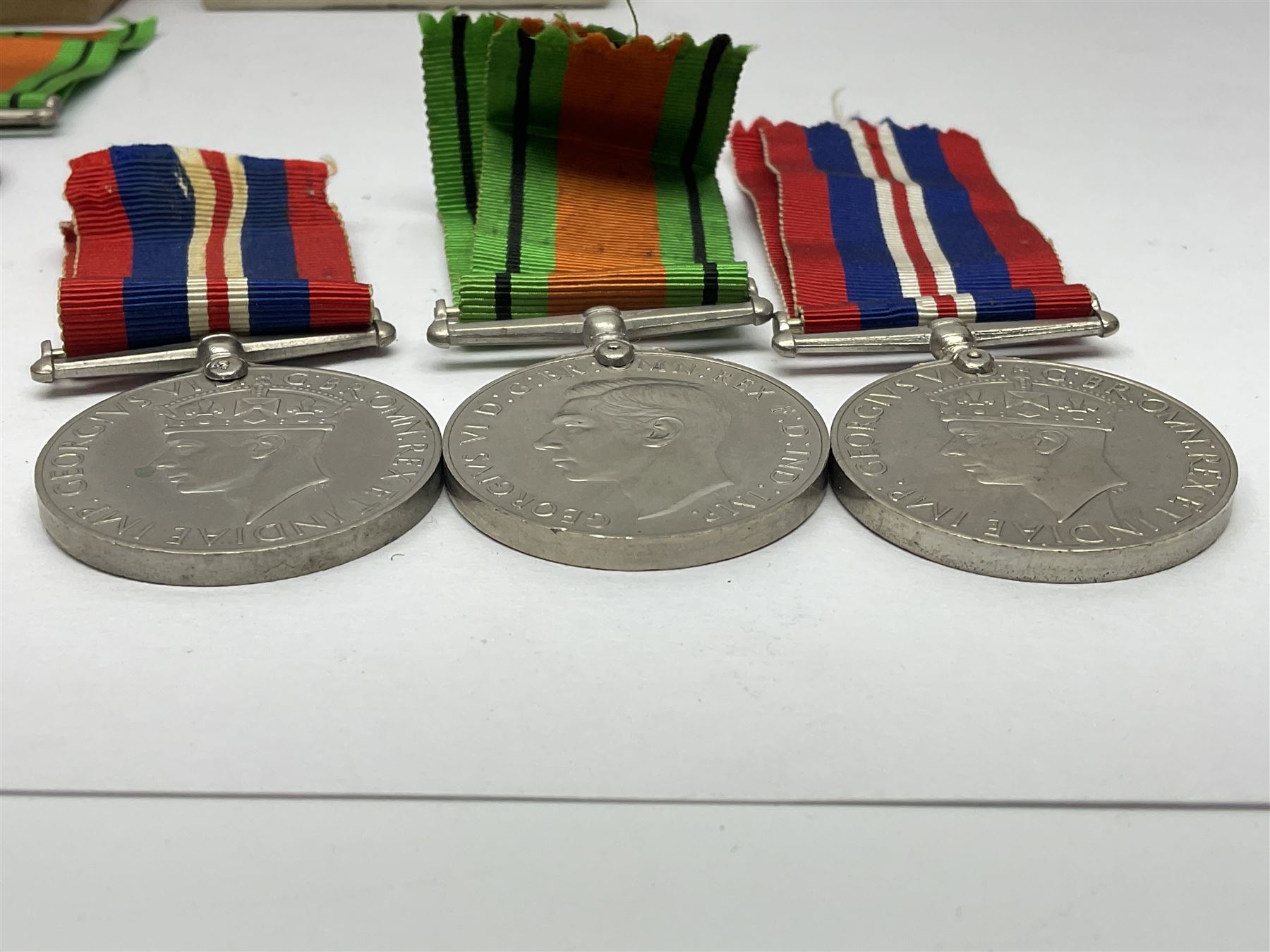 Twelve WW2 medals comprising four 1939-1945 war medals, four Defence medals, three 1939-1945 Stars and Africa Star; all with ribbons; some as groups in two issue boxes with slips