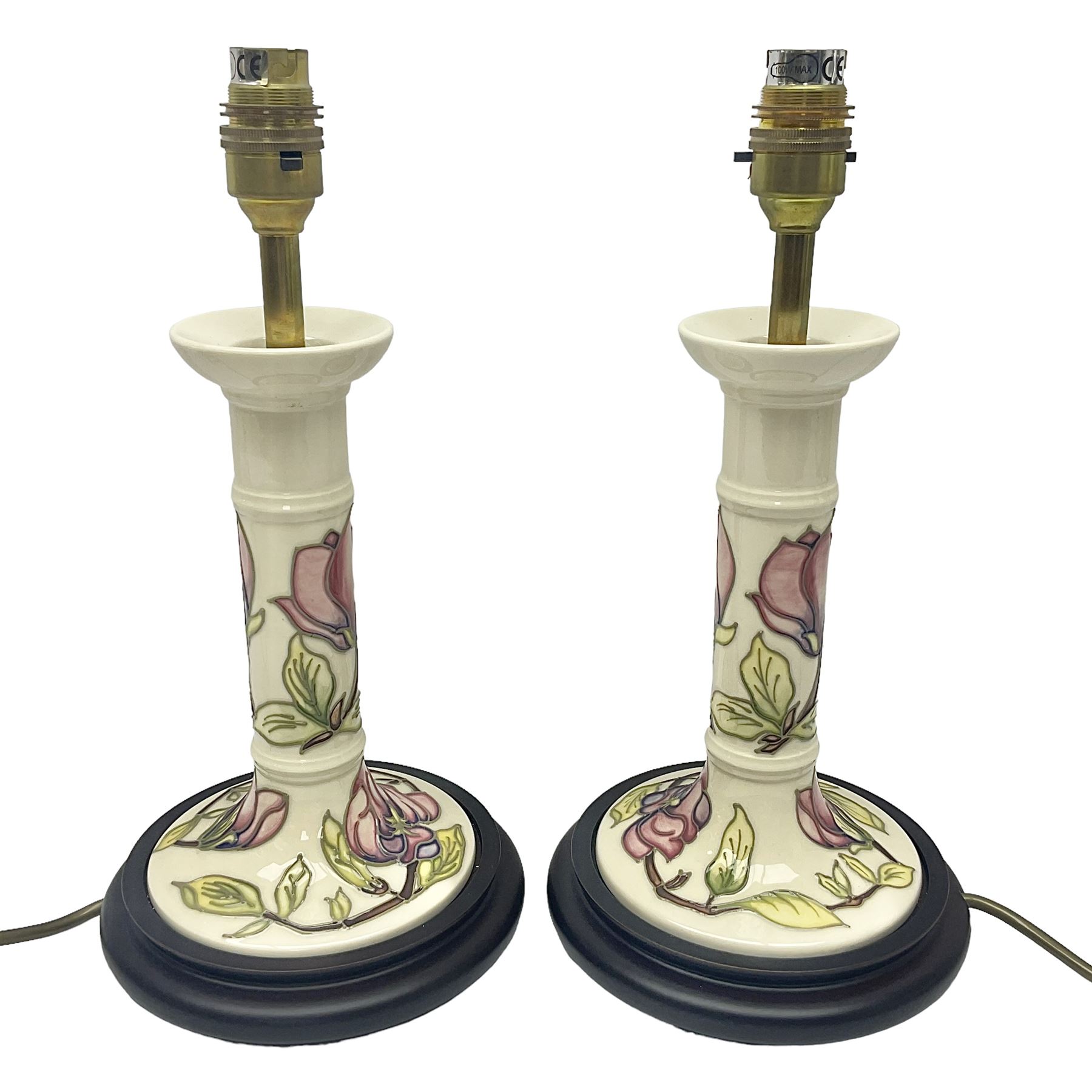 Pair of Moorcroft table lamps of candlestick form in magnolia pattern, with Moorcroft shades, H50cm 
