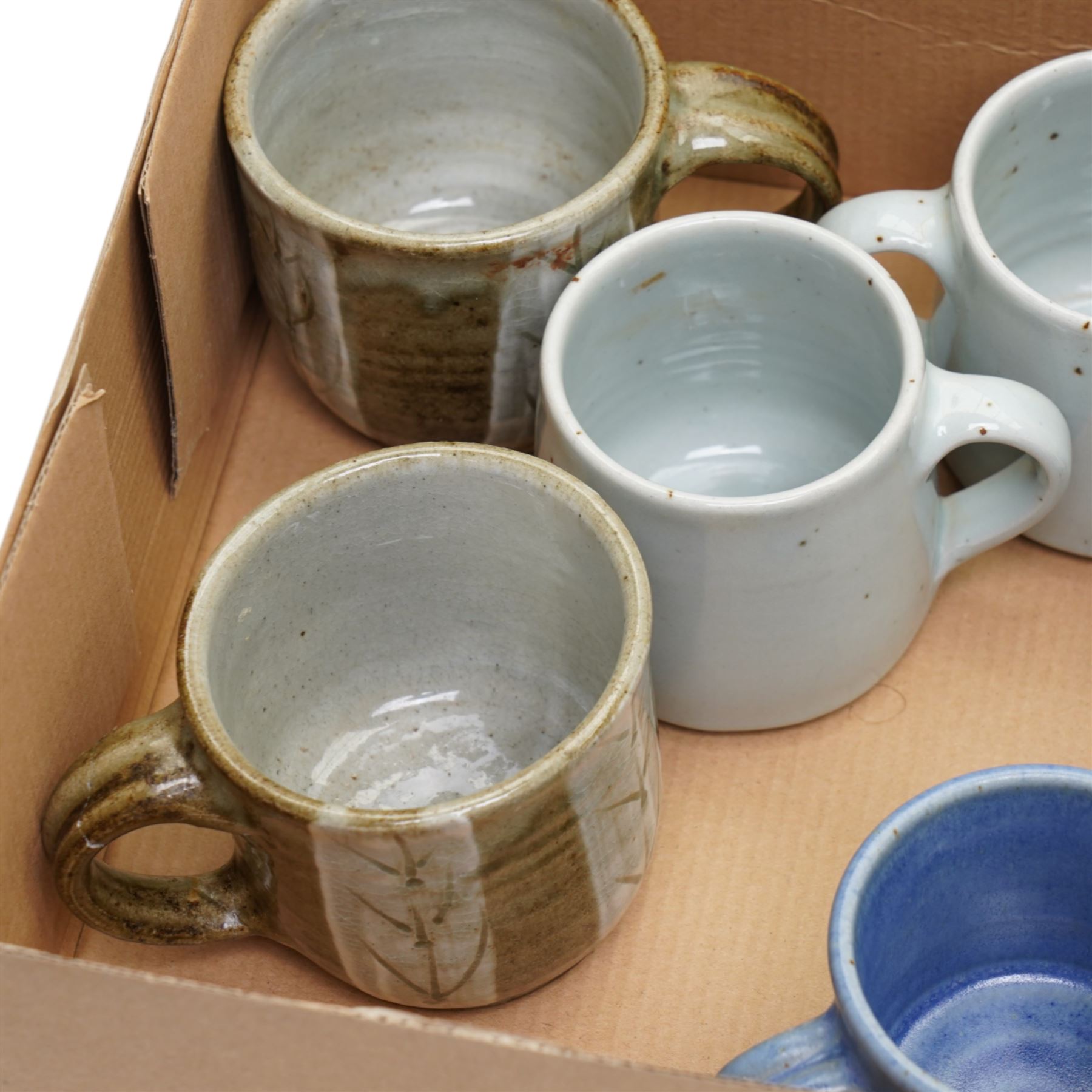 Tony Gant (British 20th Century) - set of six studio pottery stoneware mugs, in various blue glazes, with impressed marks to bases, together with two other studio pottery mugs, unmarked (8)