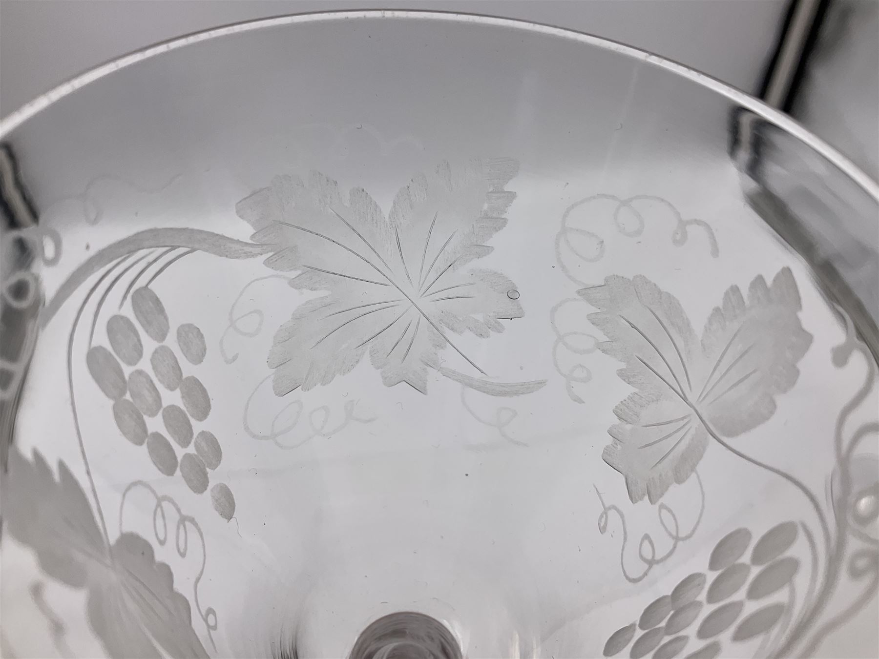 Set of three 18th century style wine glasses, each with funnel bowl etched with fruit vine, upon a double series air twist stem and circular foot, H17cm