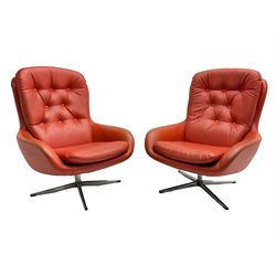 Pair mid-20th century circa.1974 swivel lounge chairs upholstered in buttoned red faux leather, on polished metal base