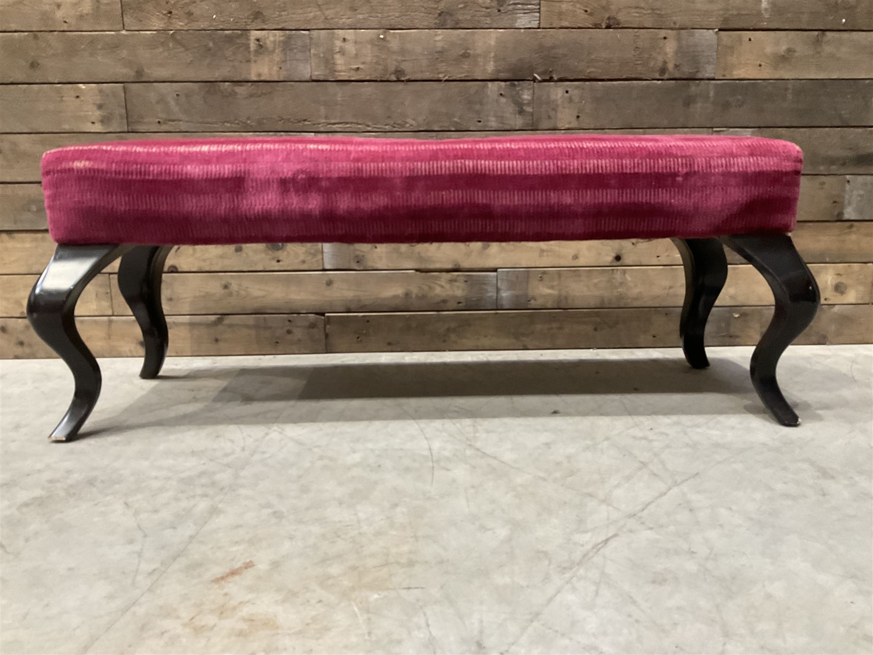 Large rectangular footstool upholstered in a maroon fabric with cabriole supports