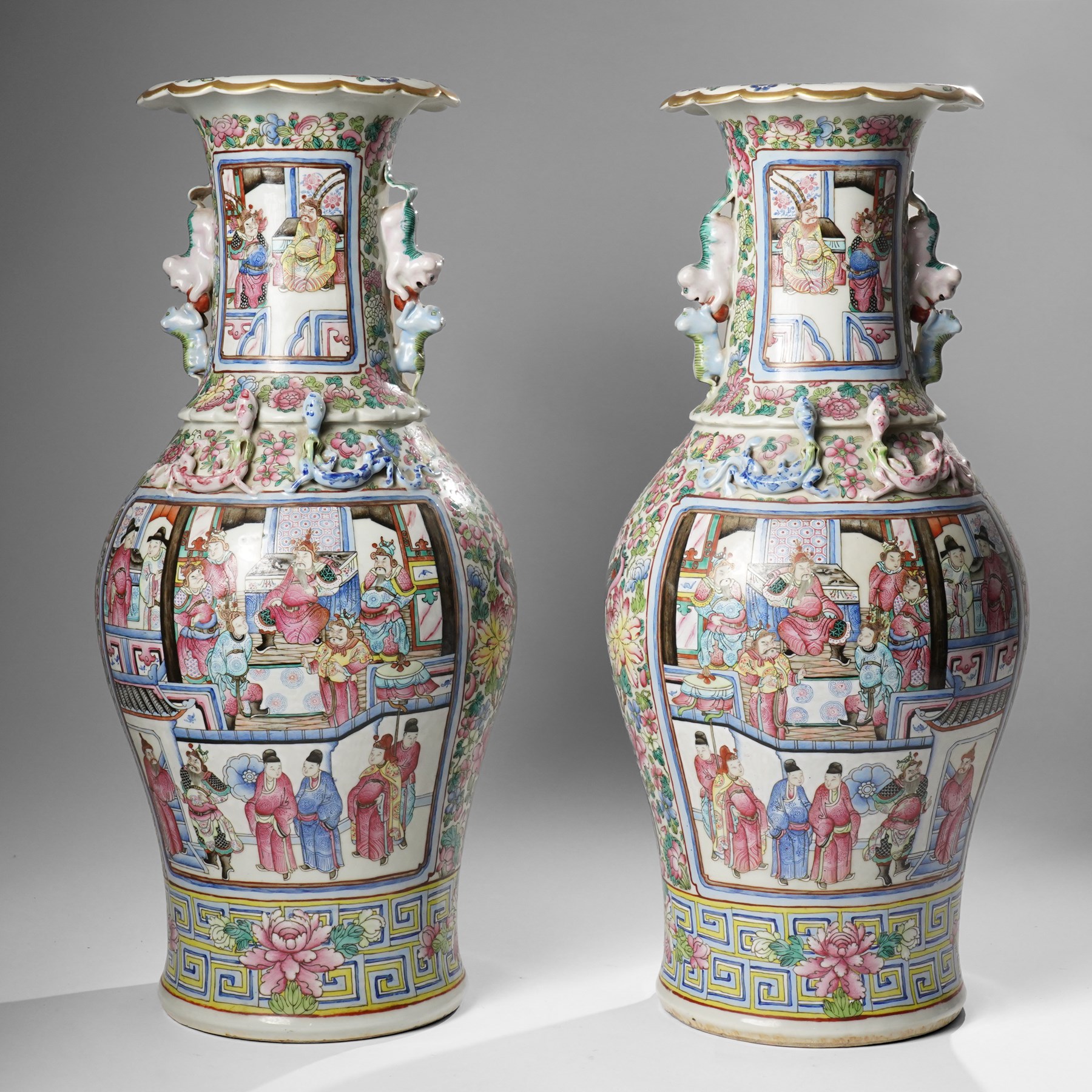 Large pair of 19th century Cantonese famille rose vases, each painted with various courtly scenes, including a display of warriors fighting on horseback before an official and his attendants, double Buddhist lion handles and applied at the shoulders with chilong, the lower band painted with Greek key motif, H58cm (2)