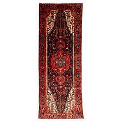 North West Persian runner, the indigo field centred by a red elongated hexagonal medallion...
