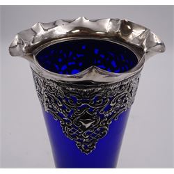 Victorian silver mounted blue glass trumpet vase, the silver mounts with pierced and embossed floral, C scroll and lattice decoration, with frilled rim, upon stepped circular foot, hallmarked Henry Matthews, Birmingham 1899