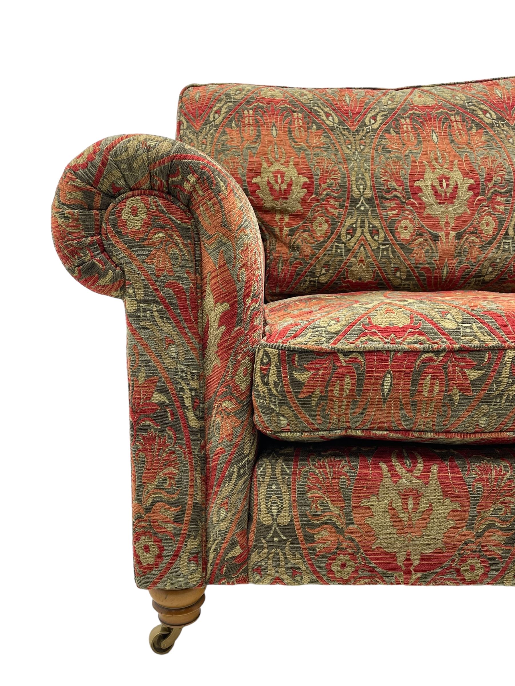 Duresta - 'Beaminster' grande two-seat sofa, traditional shape with rolled arms, upholstered in 'Althorp' russet and stone floral pattern fabric, on turned feet with brass castors
