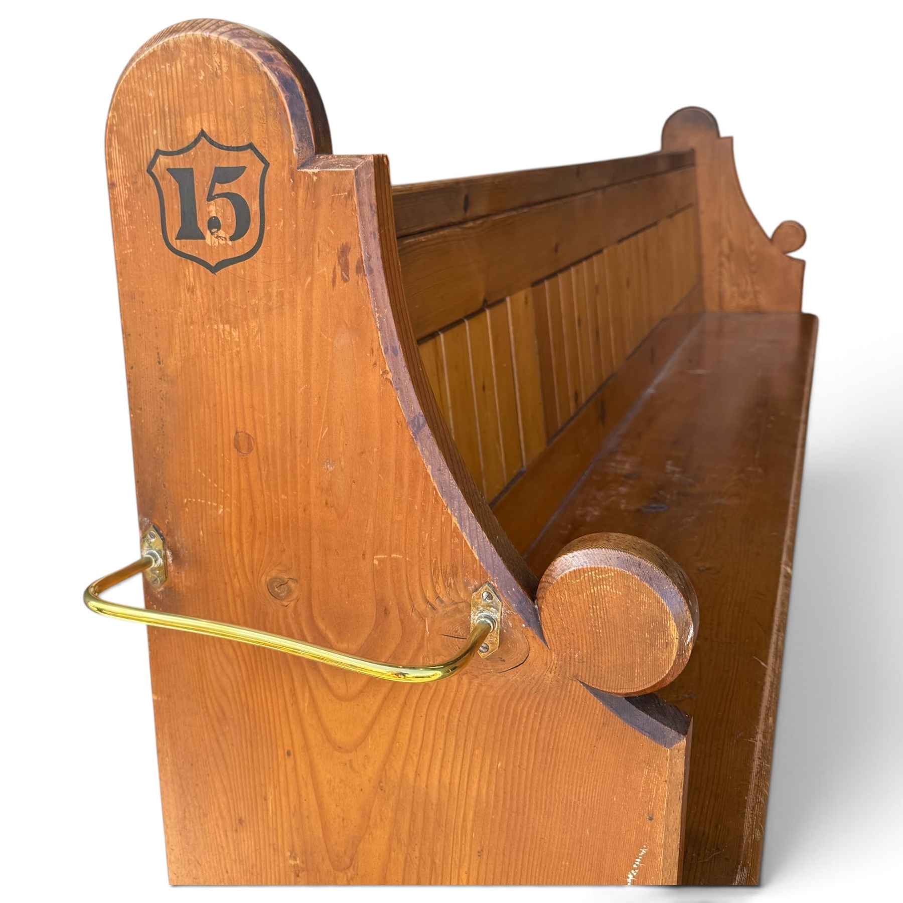 Early 20th century stained pine ecclesiastical church pew, the shaped end supports flanking slatted and panelled back, with black stencilled number '15' to the side