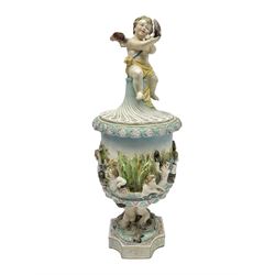 Early 20th century continental pedestal jar with cover, the bowl held aloft by four mermaids and decorated with putti playing instruments in a lake, the fluted domed cover topped with cherub playing a horn, H38cm