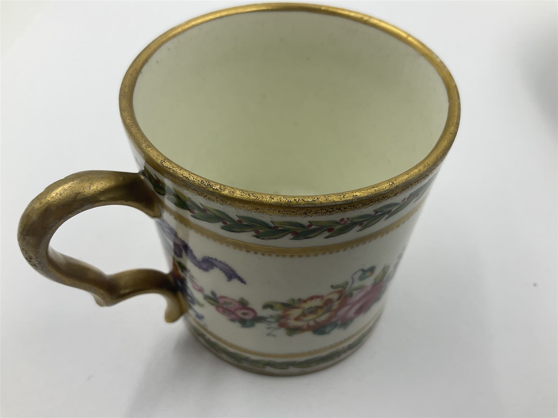 Sèvres soft paste porcelain coffee can and saucer with date code for 1780, painted with pink oval panels bordering bouquets of flowers, united by swags of flowers tied with purple ribbons, within laurel leaf borders, interlaced LL monogram enclosing date letters CC above painters marks for Nicquet, coffee can H7.5cm, saucer D15cm