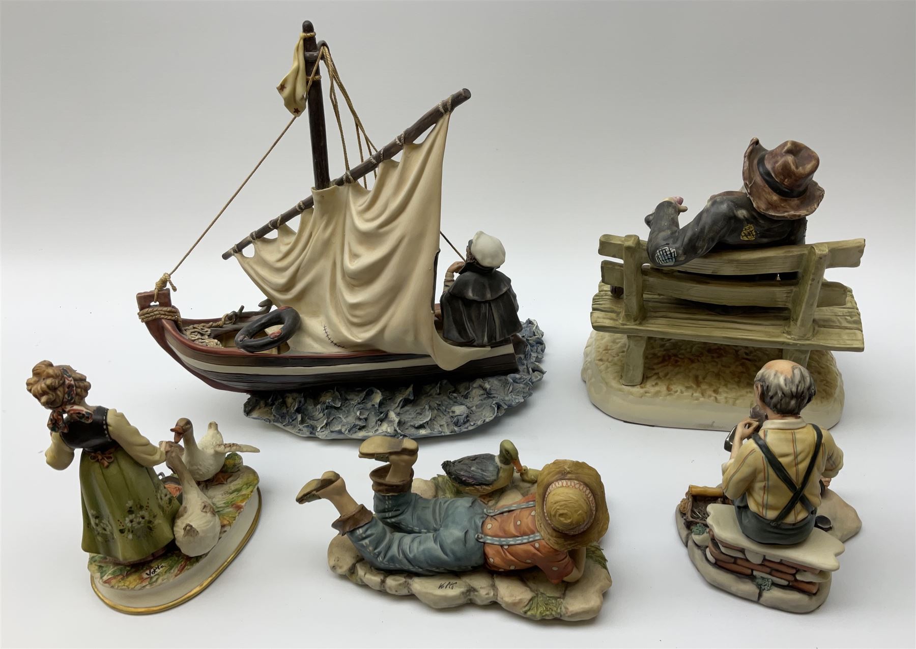 Collection of Capodimonte figures, comprising 'Home and Dry' H33.5cm, girl feeding geese H19cm, cobbler H17cm, boy lying down H11cm, and a Naples figure of man on a bench H27cm.   