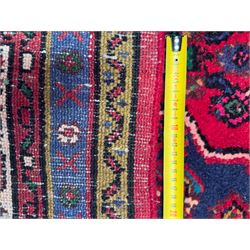 Northwestern Persian Hamadan hand-knotted rug, madder red field with a lozenge medallion enclosing an ivory centrepiece, indigo spandrels within an ivory border of stylized floral motifs between multiple guard borders 