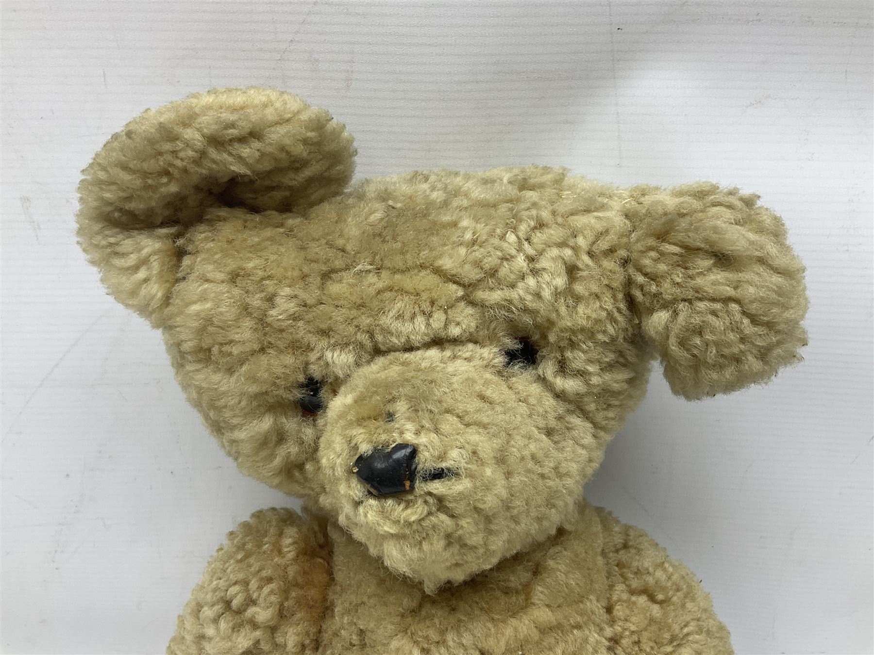 1950s sheepskin plush covered teddy bear with musical movement, the revolving head with applied eyes, leather nose and stitched mouth, jointed limbs with leather pads H50cm