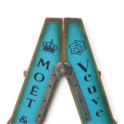 Contemporary wooden folding stepladder, three treads to each side, turquoise painted panels bearing champagne logos, with metal hinges and folding stays