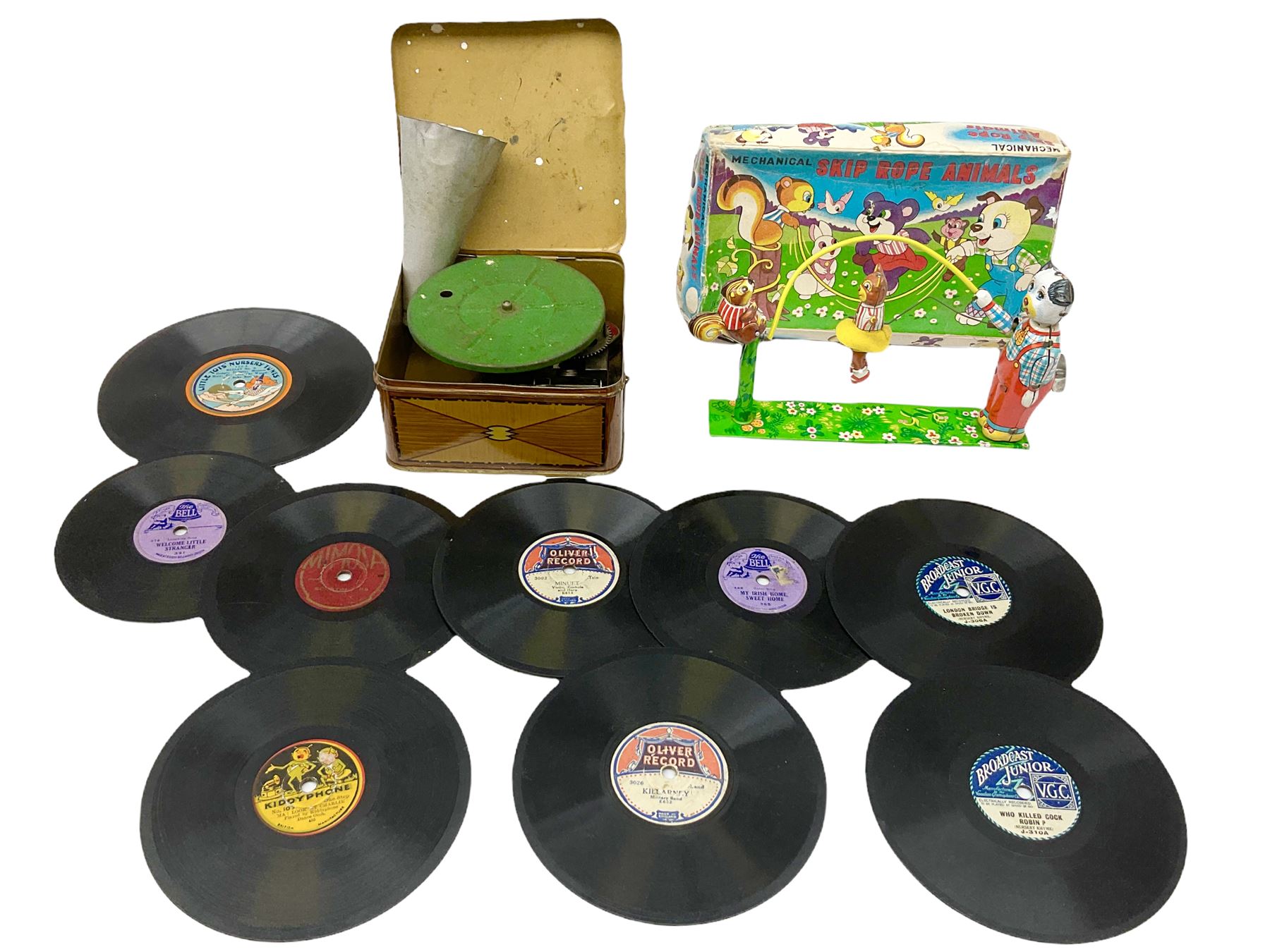Gebruder Bing Germany Pigmyphone child's portable toy gramophone in woodgrain finish tin-plate box with key and tin of needles L15cm; and nine small records of nursery rhymes; together with a Japanese tin-pate 'Skip Rope Animals' clockwork toy, boxed.