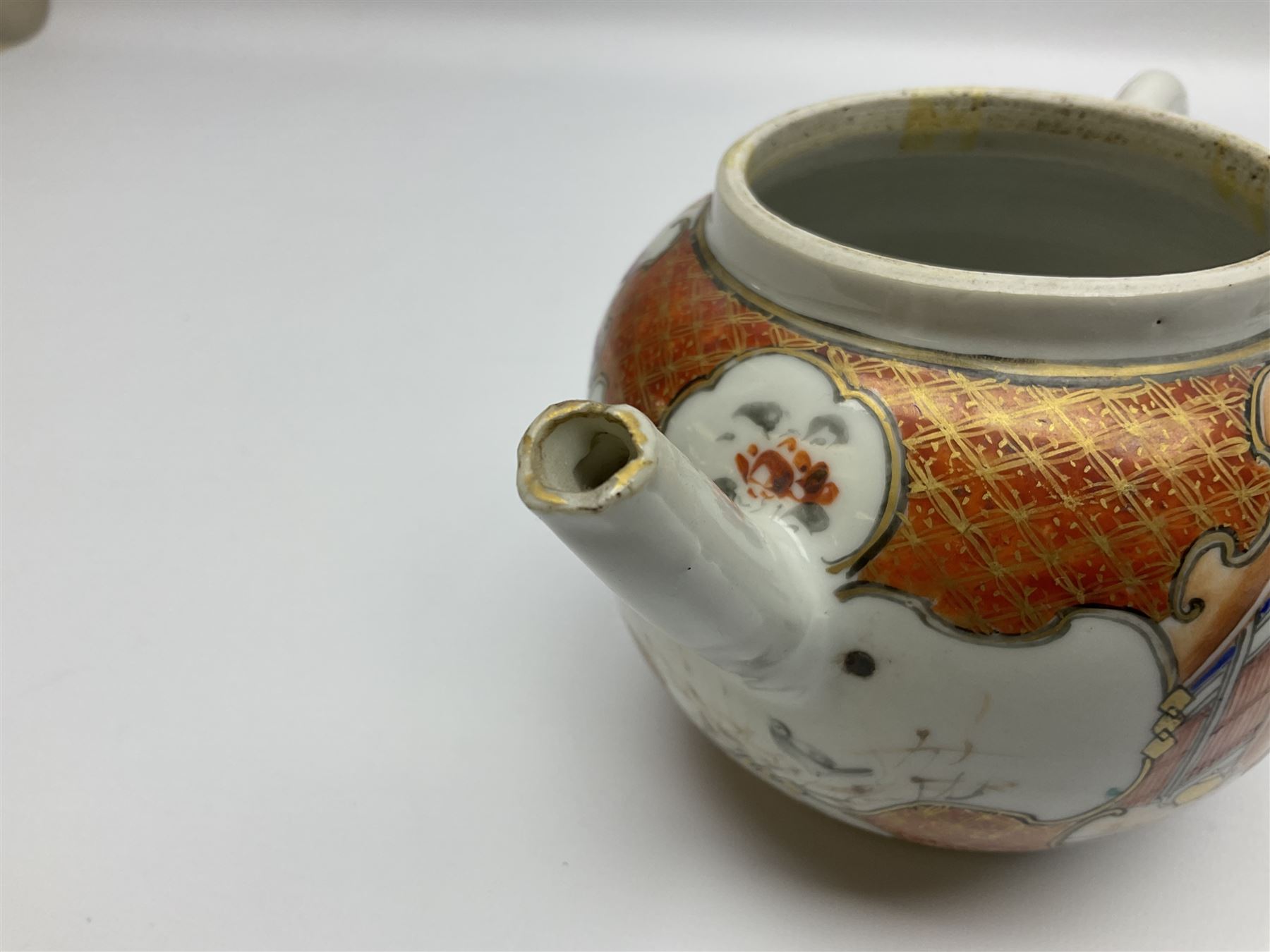 Two late 18th/early 19th century Chinese export teapots, the largest example of globular form with curved handle and straight spout, decorated in the Mandarin style with figural scenes surrounded by red scale reserves, H13.5cm, the second smaller example decorated in underglaze blue with two musicians in a landscape set with willow tree and fence, H10.5cm

