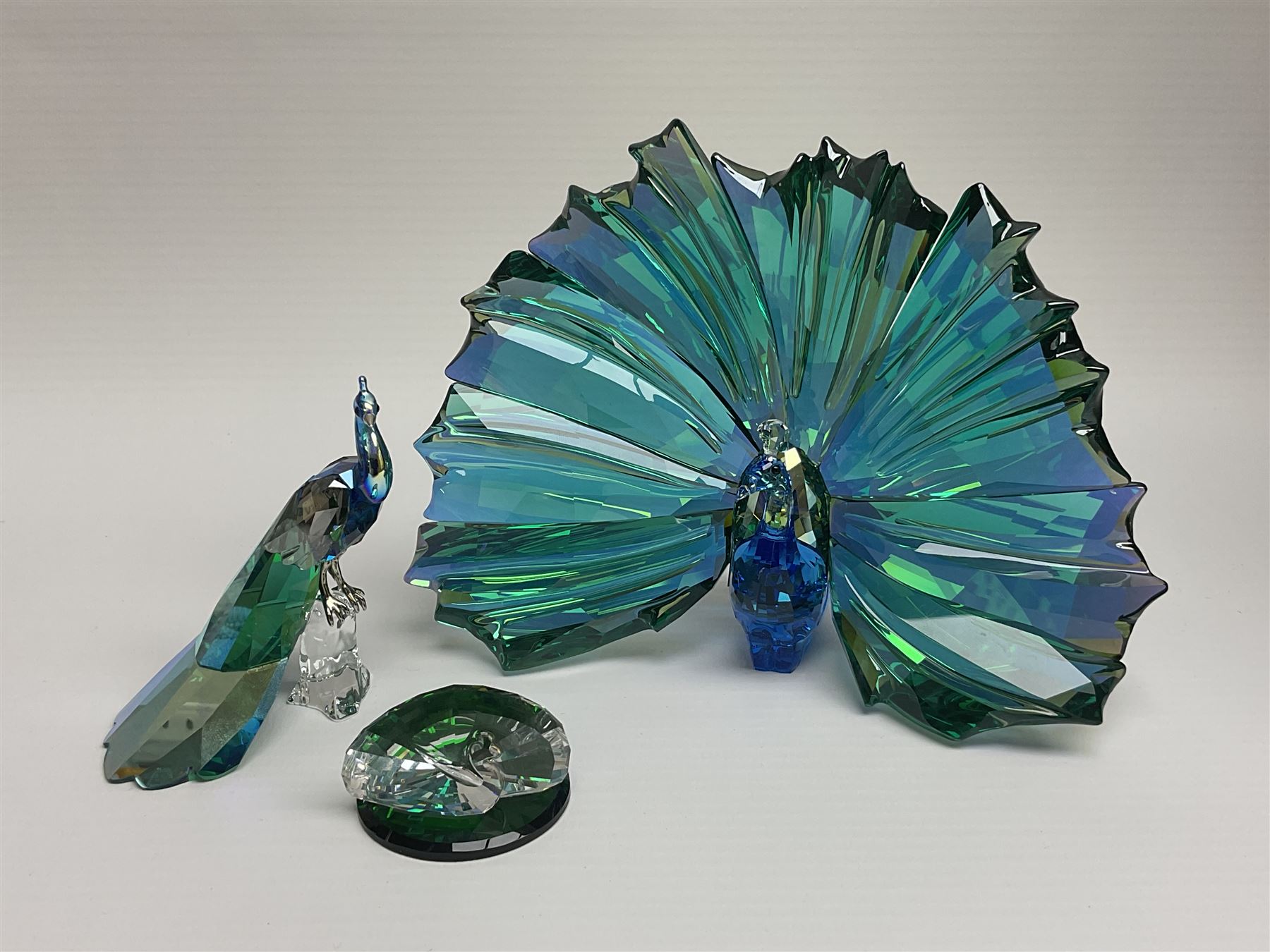 Swarovski Crystal SCS Edition peacock, Arya, together with a Swarovski Crystal peacock, perched on rock and small Swarovski Crystal sign, with peacock motif, tallest H11cm