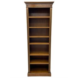 Georgian design walnut open bookcase, projecting cornice over figured banded frieze flanked by roundels, fitted with six adjustable shelves with flanking fluted uprights, on skirted base