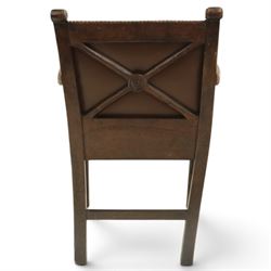 DD CL - Early 20th century oak open armchair, rectangular back with scrolled uprights, brown upholstered back and seat with brass stud edging, shaped open arms on turned supports, square legs united by stretchers