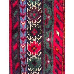 Northwestern Persian Cirjan hand-knotted carpet, madder red field with three linked stepped lozenge medallions in blue, ivory and green, flanked by angular motifs within a dark green border of serrated leaves and rosettes 