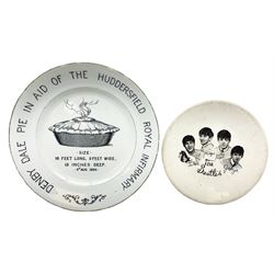 Early 20th century commemorative plate depicting a black transfer image of a steaming pie with text surrounding reading 'Denby Dale Pie in aid of the Huddersfield Royal Infirmary', marked H.G.D.D to reverse, D24cm, and a The Beatles plate