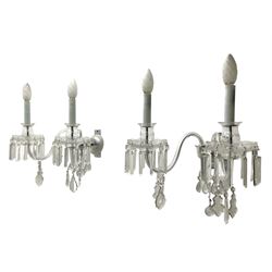 Pair of cut glass two branch wall sconce candelabras, each with S scroll extending branches with shaped and bevelled circular drip trays, hung with pendant drops