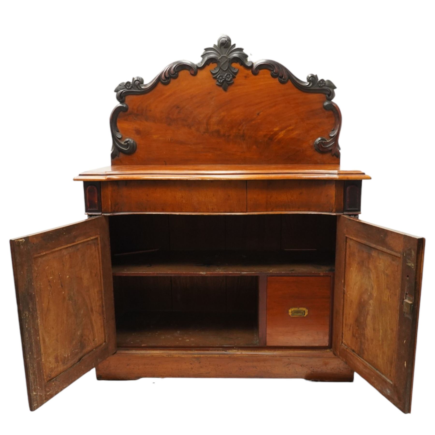 Victorian mahogany chiffonier, raised back with applied carvings, above a serpentine fronted base, a single frieze drawer, above a cupboard with shelf and drawer with campaign handle, raised on a plinth base