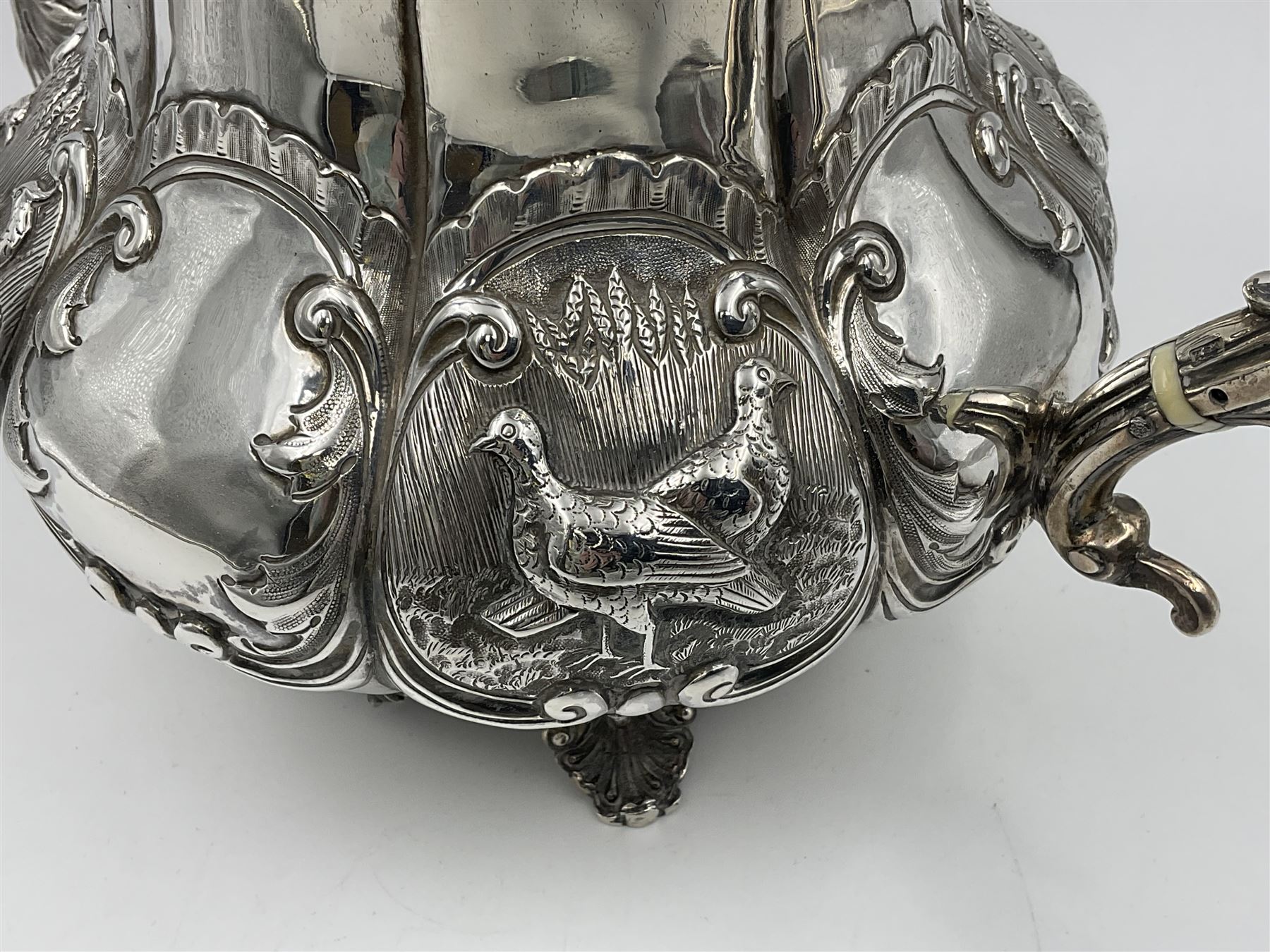 Victorian silver three piece tea service, comprising teapot, twin handled open sucrier, and milk jug, each of bellied form with acanthus capped scroll handles, the sides embossed with alternating scroll edged vacant panels and panels containing a pair of birds, upon four palmette feet, the teapot with ivory insulators to handle, and bird finial to the hinged domed cover, hallmarked William Hunter & Son, London 1861, teapot H19cm, including handles sucrier H13.5cm, including handle milk jug H12cm

This item has been registered for sale under Section 10 of the APHA Ivory Act