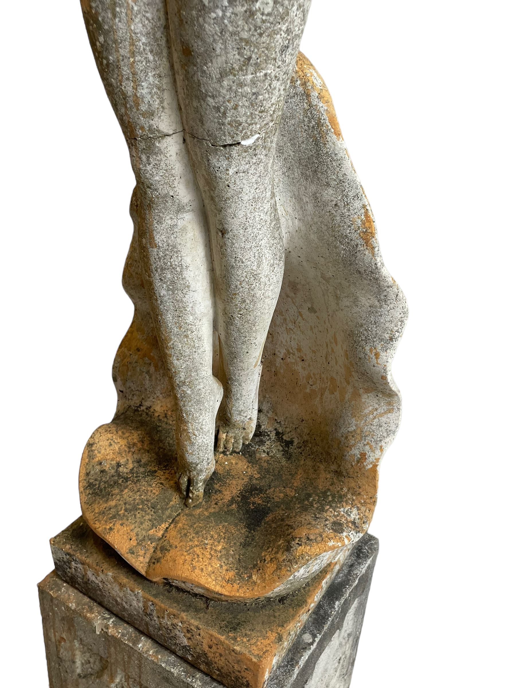 Cast stone two-piece garden figure of the Birth of Venus, depicting the goddess emerging from a stylised shell, on square base with stepped moulded plinth 