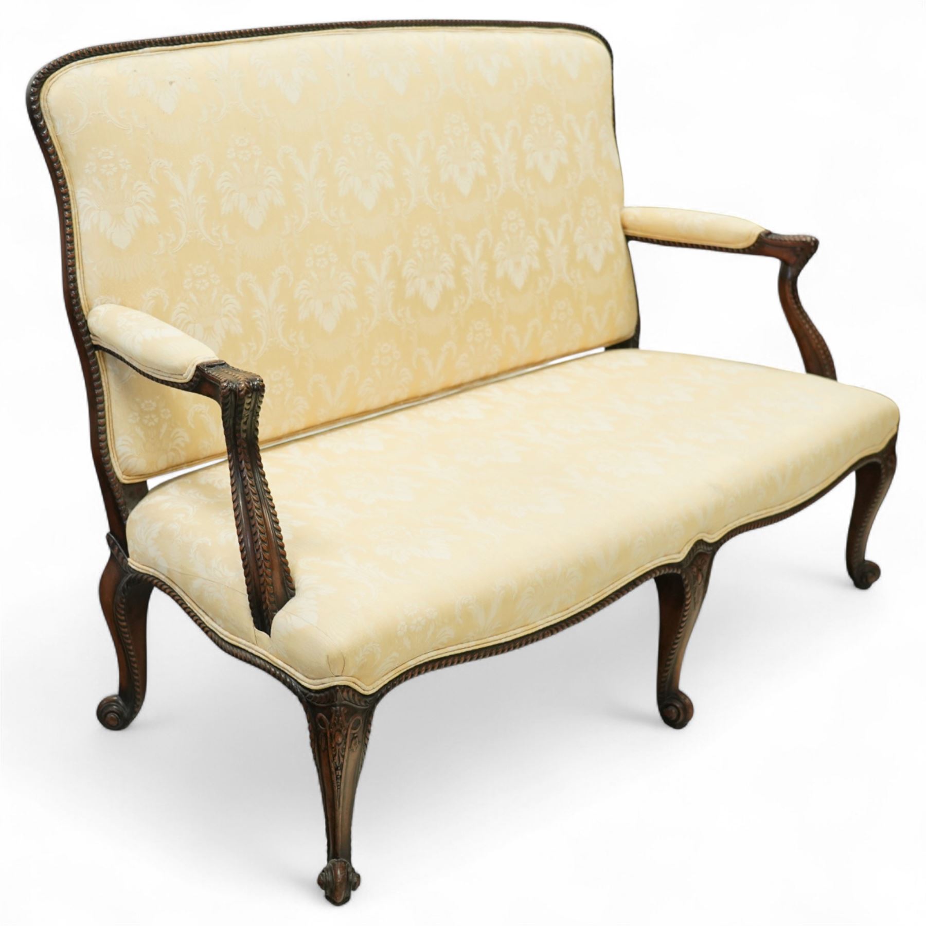 Early 20th century mahogany settee in the George III style, upholstered in pale yellow damask fabric, moulded serpentine seat rail with carved foliate detail, on cabriole supports with acanthus carved knees and scroll feet