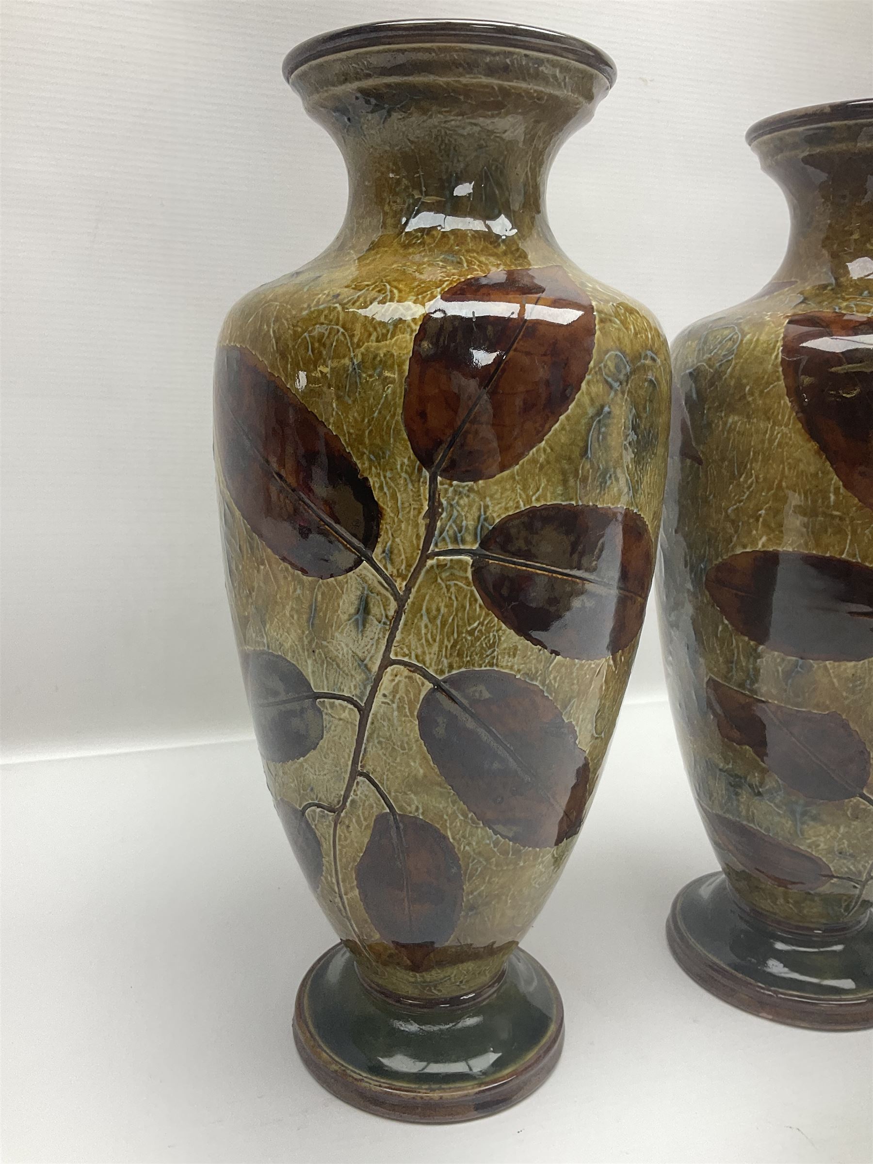 Pair of Royal Doulton Stoneware Vases with leaf decoration, by Ethel Beard, impressed marks to base numbered 6768 and 8222 and initials EB, H32cm