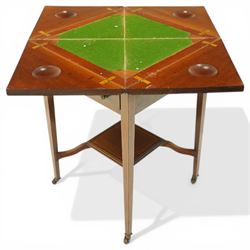 Edwardian inlaid mahogany envelope table, square top with triangular leaves revealing a baized lined interior and wells, raised on tapering supports united by an under tier, terminating in brass castors