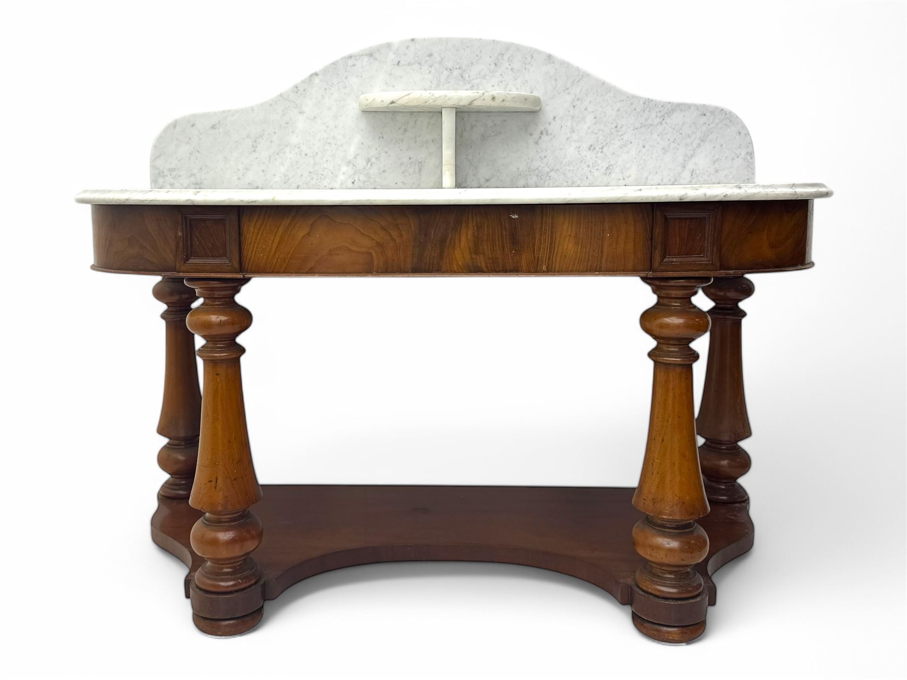 Mid-19th century mahogany washstand, the serpentine white marble top with raised gallery back and central shelf above a frieze drawer, supported by turned columns united by a shaped undertier, raised on bun feet
