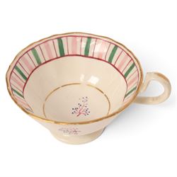 Late 19th century tea service, decorated with a green and pink strips, with internal decoration of budding branch within a gilt band upon a white glazed ground, comprising  twin handle lidded sucrier, milk jug, three serving plates, nine cups and saucers and four teacups