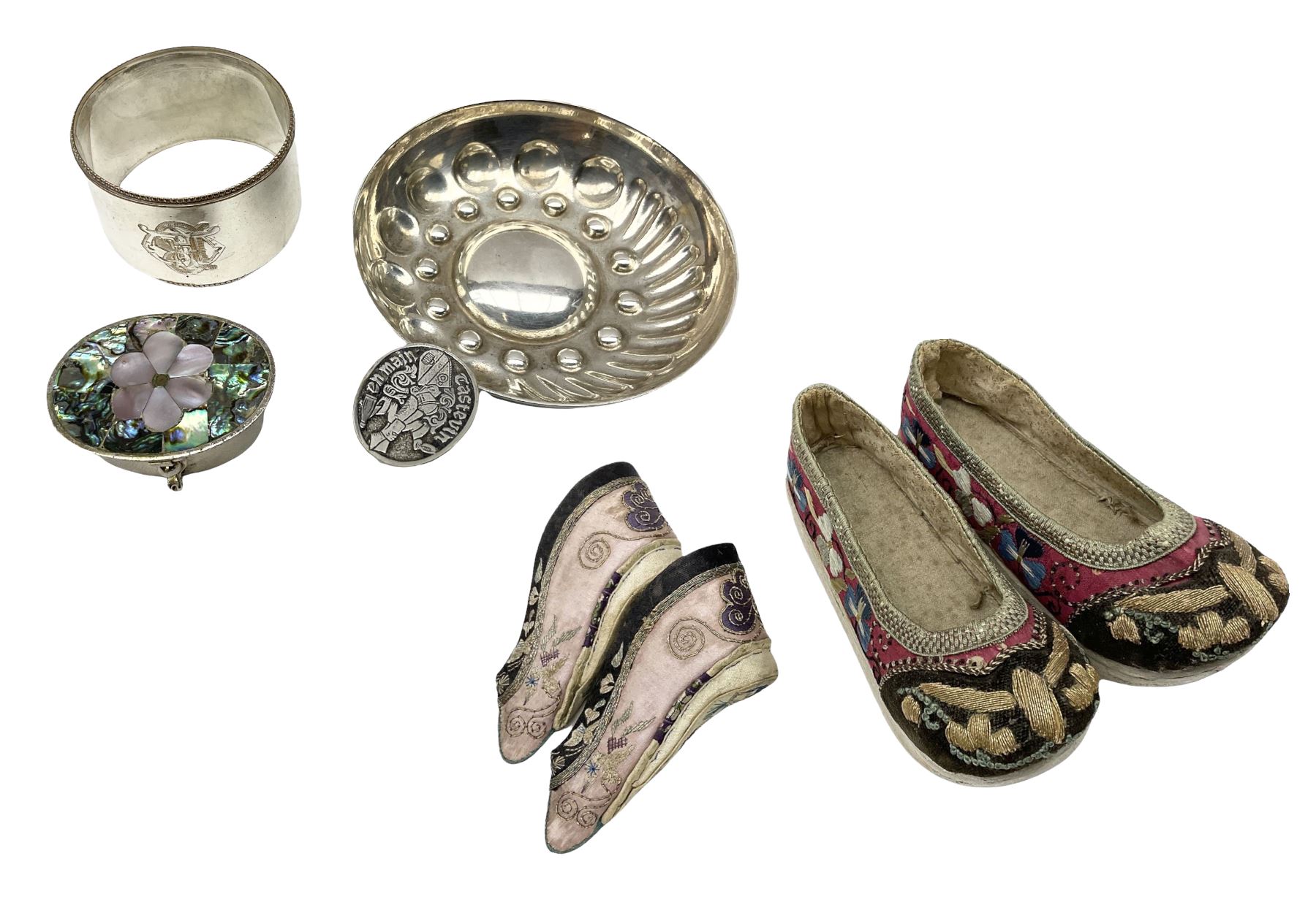 French silver plated wine taster of typical form, stamped, together with a silver plated napkin ring, and an 'Alpaca Silver' pill box with mother of pearl detailed cover, (3) together with Two pairs of late 19th/early 20th century Chinese Lotus shoes for binding feet, the first with purple silk heavily embroidered with ornate floral motifs, L10cm the second larger fuschia and black pair with thicker sole embroidered with flowers, L14cm